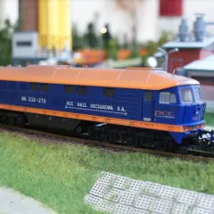 Model lokomotywy BR232 w barwach PCC Rail Szczakowa S.A. na makiecie kolejowej.