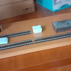 Diorama kolejowa z wieżą wodną, wagonem węglowym i budynkiem stacyjnym.