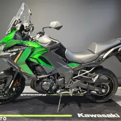 Zielony motocykl Kawasaki Versys 1100, jeden z wielu modeli tej marki, gotowy na przygodę.