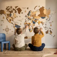 Dwóch chłopców odkrywa świat na dużej, drewnianej mapie świata na ścianie.