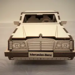 Drewniane puzzle w kształcie klasycznego Mercedesa. Model z wygrawerowanym napisem "Mercedes-Benz" na tablicy rejestracyjnej.