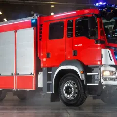 Nowoczesny model wozu strażackiego MAN, lśniący czerwienią, gotowy do akcji.