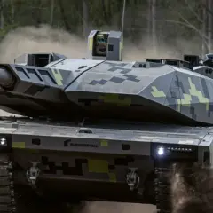 Nowoczesny czołg KF51 Panther w kamuflażu, pędzący przez kurz i dym.
