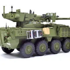M1128 Stryker, zielony pojazd opancerzony z wieżyczką, działkiem i karabinem maszynowym, gotowy do akcji.