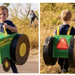 Chłopiec w zielonym, kartonowym traktorze John Deere, gotowy do pracy na polu.