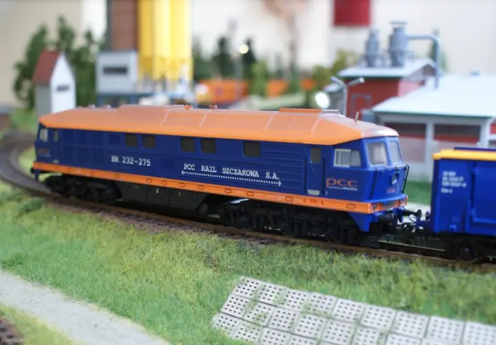 Model lokomotywy BR232 w barwach PCC Rail Szczakowa S.A. na makiecie kolejowej.