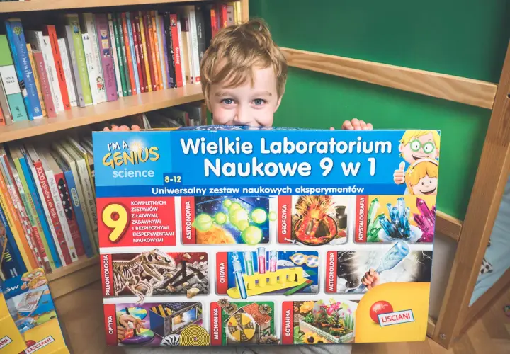 Chłopiec z radością prezentuje zestaw naukowych gadżetów "Wielkie Laboratorium Naukowe 9 w 1", gotowy do odkrywania tajemnic nauki.