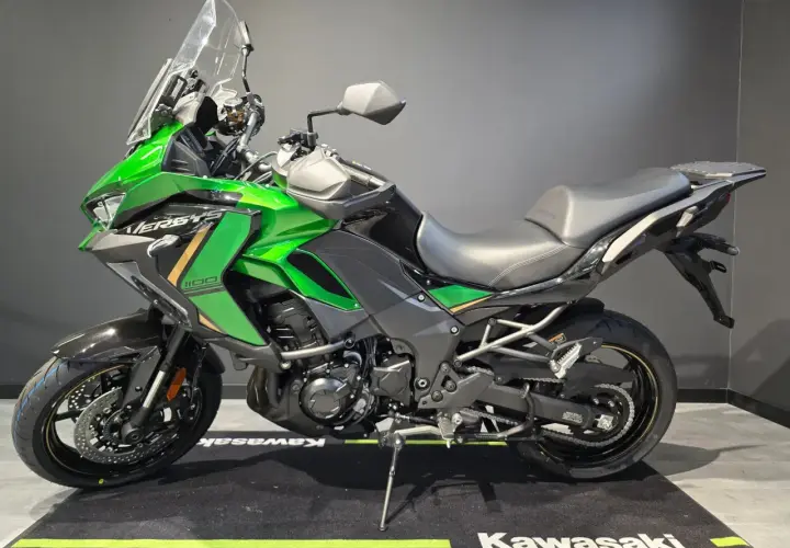 Zielony motocykl Kawasaki Versys 1100, jeden z wielu modeli tej marki, gotowy na przygodę.