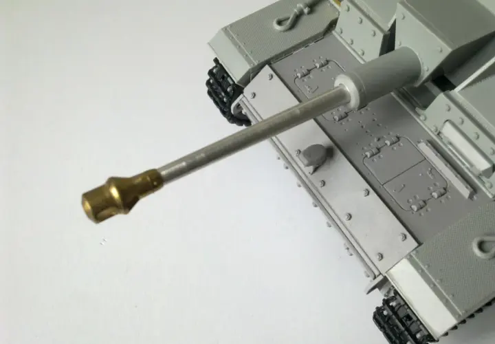 Model czołgu z widoczną metalową lufą, gotową do oddania strzału.