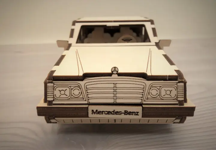 Drewniane puzzle w kształcie klasycznego Mercedesa. Model z wygrawerowanym napisem "Mercedes-Benz" na tablicy rejestracyjnej.