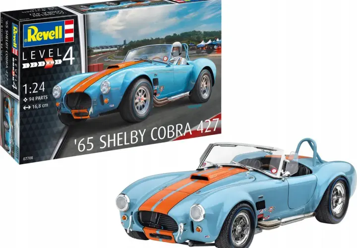 Niebieski model samochodu '65 Shelby Cobra 427 z pomarańczowymi pasami, obok pudełka z modelem Revell.