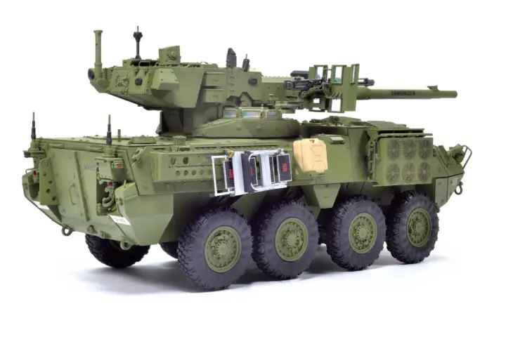 M1128 Stryker, zielony pojazd opancerzony z wieżyczką, działkiem i karabinem maszynowym, gotowy do akcji.