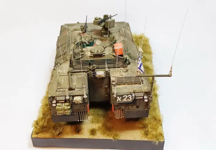 Model namer IFV, z izraelską flagą i numerem "א 23", stoi na tle trawy.