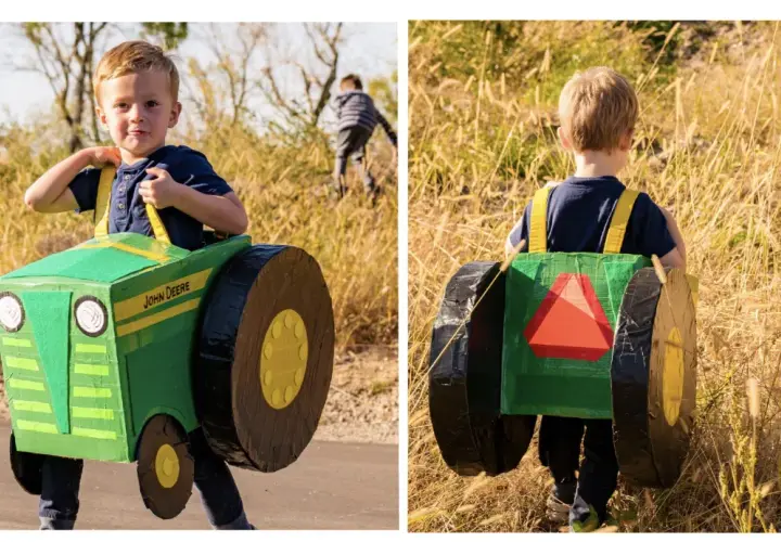 Chłopiec w zielonym, kartonowym traktorze John Deere, gotowy do pracy na polu.