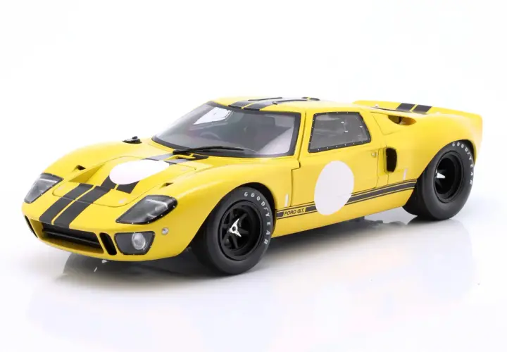 Żółty Ford GT40 z czarnymi pasami i białymi okręgami, gotowy do wyścigu.