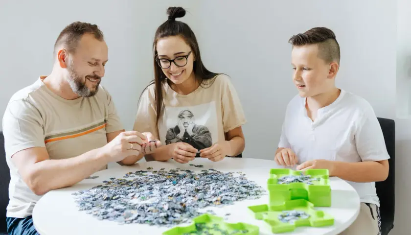 Rodzina wspólnie układa puzzle, ucząc się, jak szybko układać puzzle.
