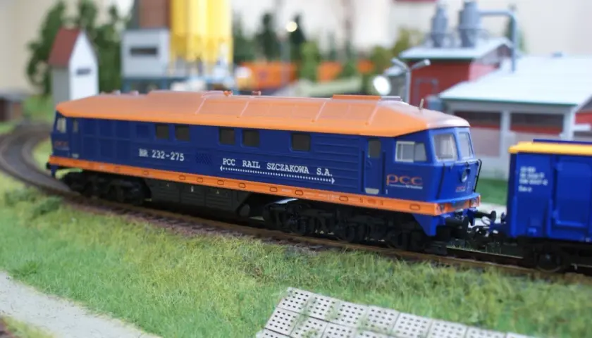 Model lokomotywy BR232 w barwach PCC Rail Szczakowa S.A. na makiecie kolejowej.