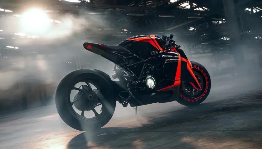 Czarny motocykl z neonowo-pomarańczowymi akcentami, wyglądający jak futurystyczne samochody z przyszłości, w zadymionym wnętrzu.