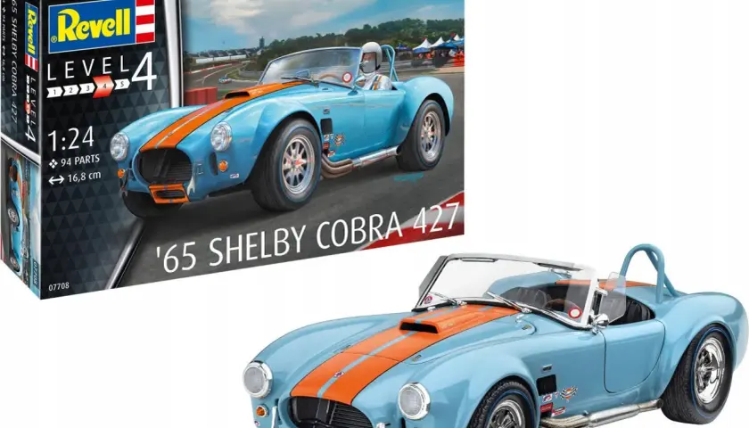 Niebieski model samochodu '65 Shelby Cobra 427 z pomarańczowymi pasami, obok pudełka z modelem Revell.