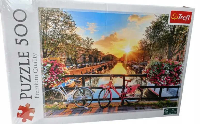 Puzzle 500 elementów z widokiem na kanał w Amsterdamie o zachodzie słońca, z rowerami i kwiatami.