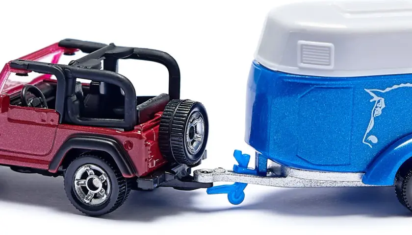Czerwony jeep z przyczepą, gotowy na przygodę.