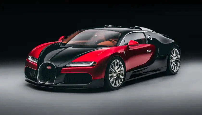 Elegancki Bugatti Veyron w dwukolorowej czerwono-czarnej karoserii, z luksusowym, brązowym wnętrzem. To ikona wśród bugatti modele.
