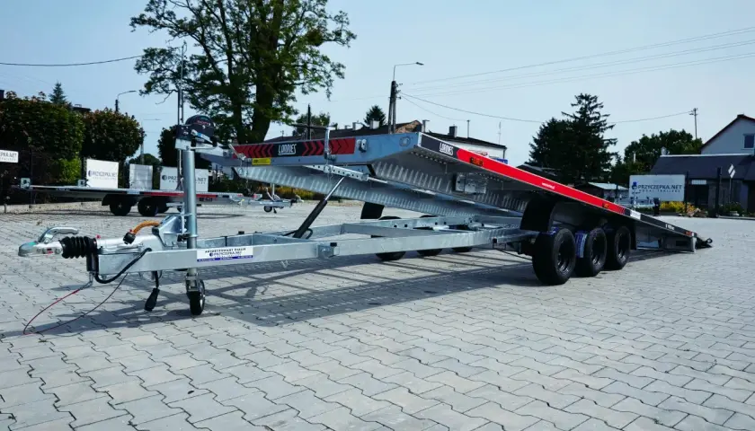 Nowa laweta do ciągnika z wyciągarką i najazdami, gotowa do transportu maszyn.