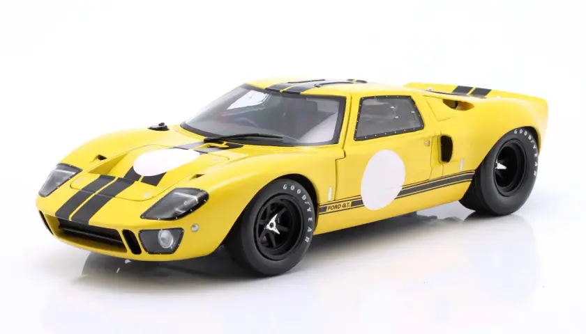 Żółty Ford GT40 z czarnymi pasami i białymi okręgami, gotowy do wyścigu.