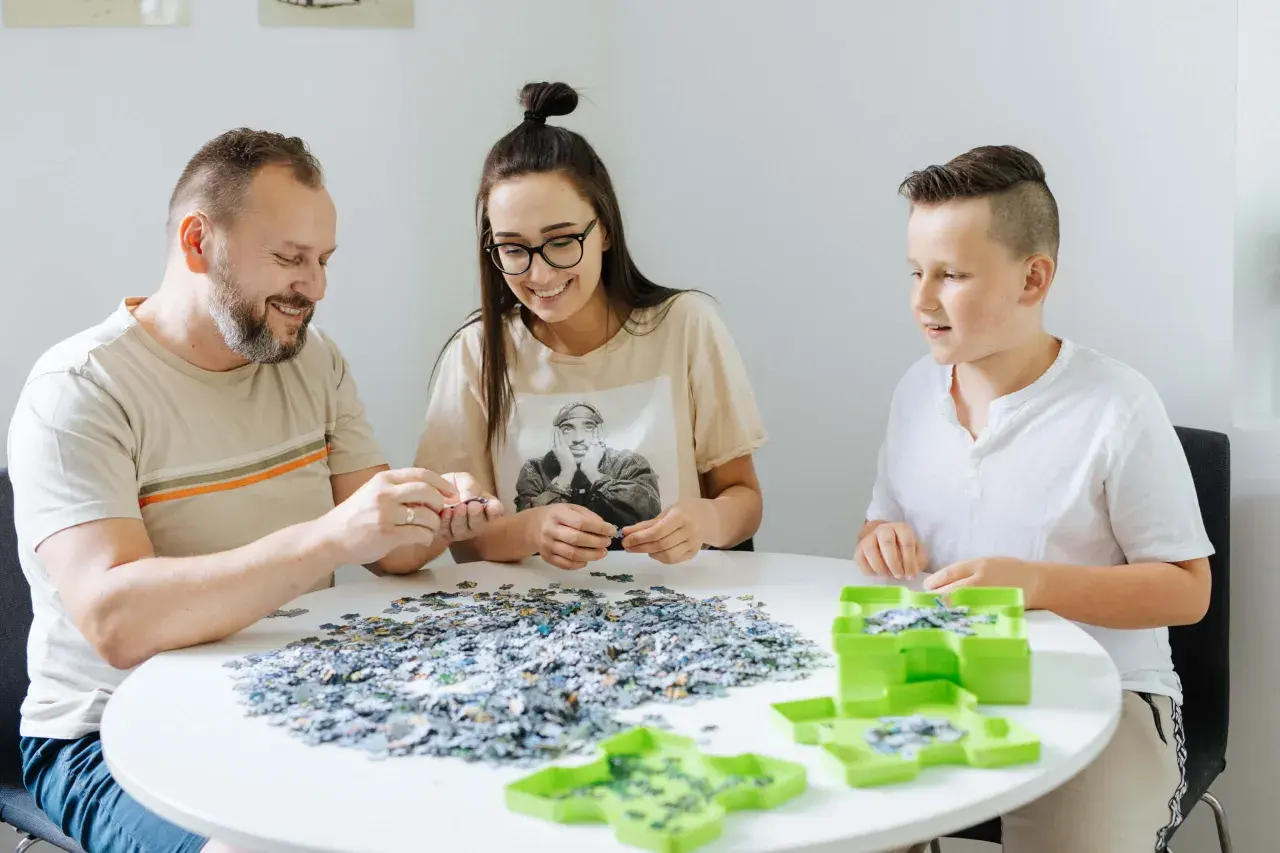 Rodzina wspólnie układa puzzle, ucząc się, jak szybko układać puzzle.