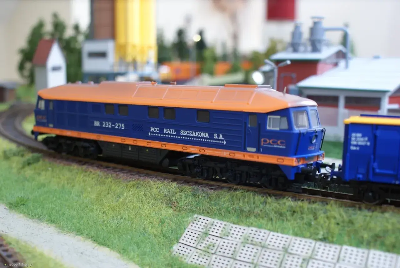 Model lokomotywy BR232 w barwach PCC Rail Szczakowa S.A. na makiecie kolejowej.