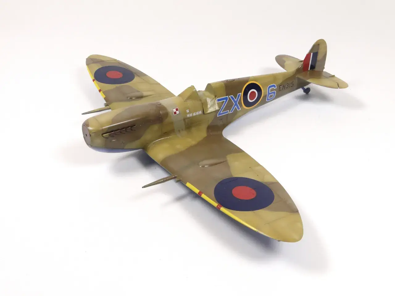 Model Spitfire w kamuflażu, z oznaczeniami ZX-6 EN315 i polską szachownicą.