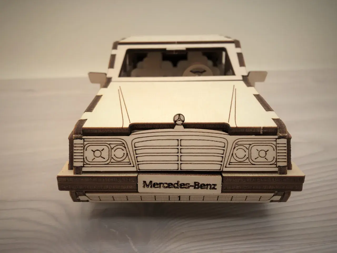 Drewniane puzzle w kształcie klasycznego Mercedesa. Model z wygrawerowanym napisem "Mercedes-Benz" na tablicy rejestracyjnej.