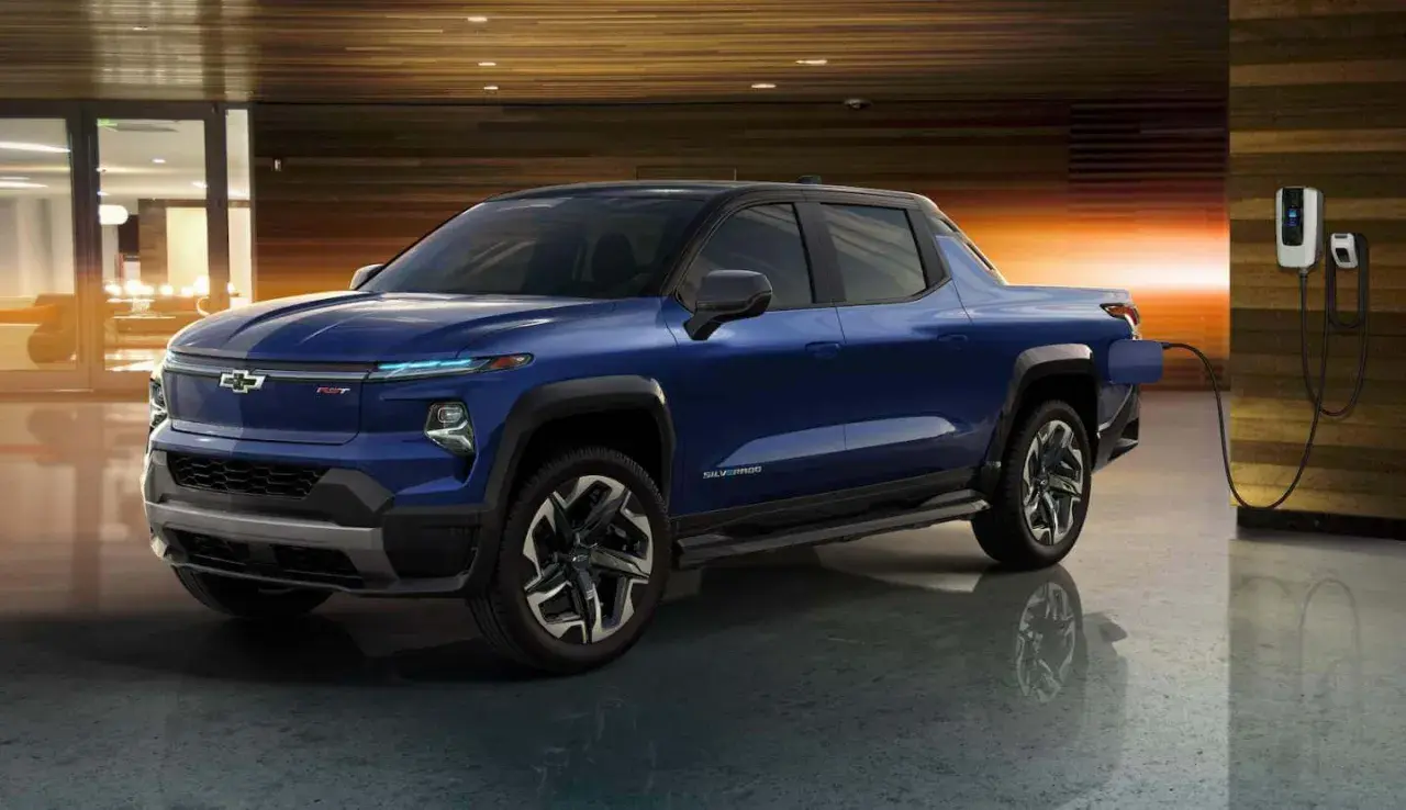 Niebieski Chevrolet Silverado EV, jeden z najnowszych chevrolet pickup modele, ładuje się w nowoczesnym garażu.