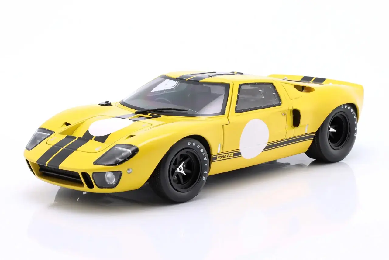 Żółty Ford GT40 z czarnymi pasami i białymi okręgami, gotowy do wyścigu.