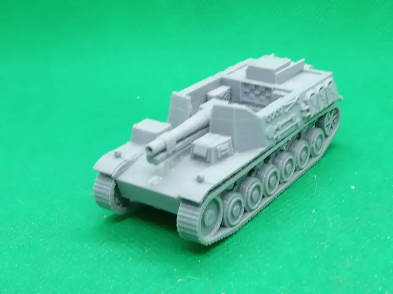 Szary model Sturmpanzer II na zielonym tle.
