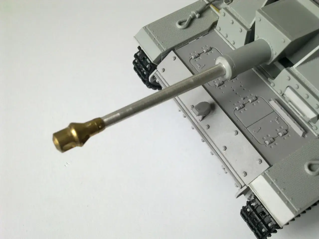 Model czołgu z widoczną metalową lufą, gotową do oddania strzału.